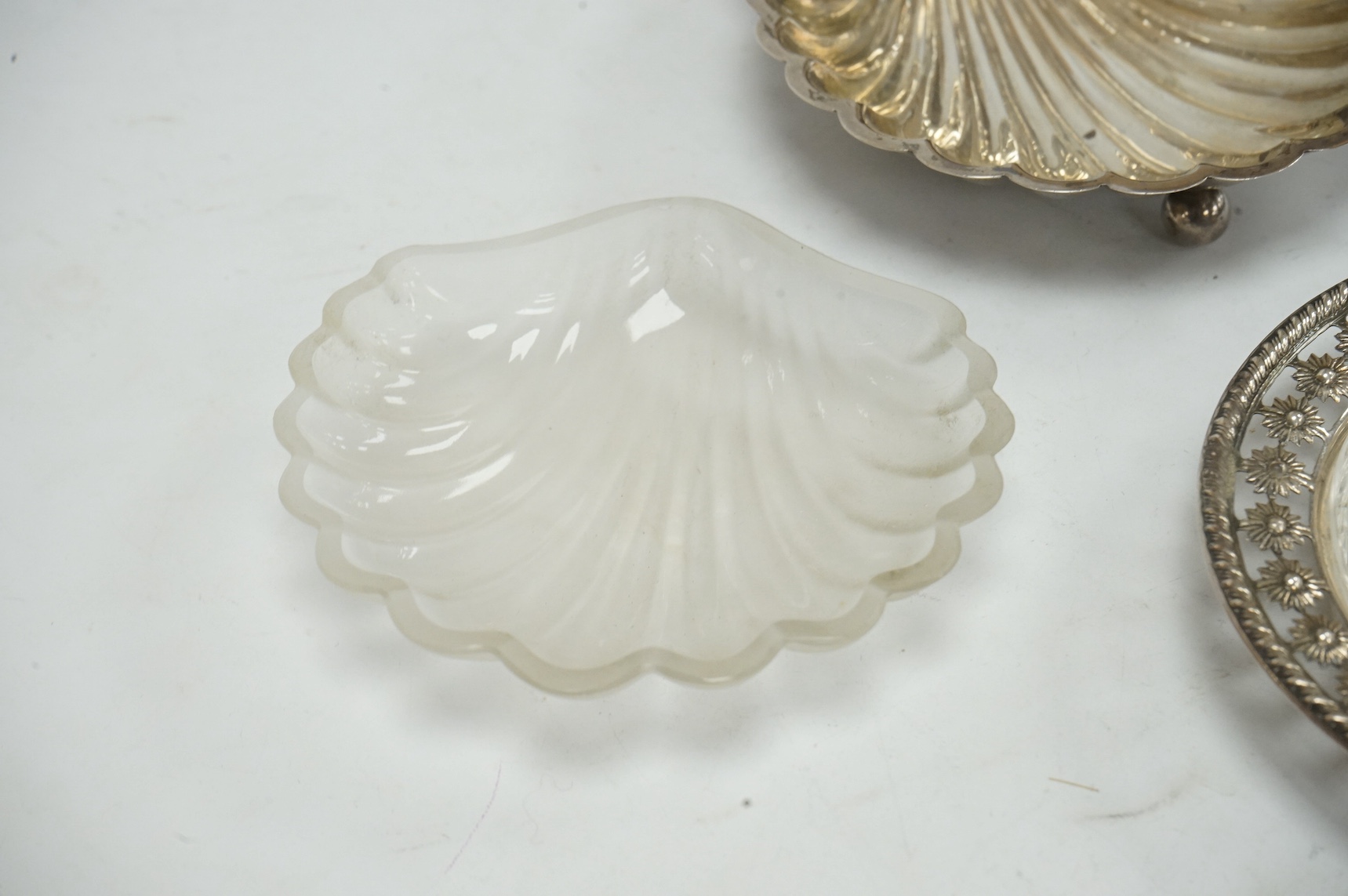 A late Victorian silver butter shell, by George Unite, Birmingham, 1897, 13.9cm, with later? glass insert, together with a silver mounted glass dish, Birmingham, 1903. Condition - fair to good